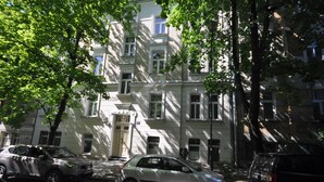 A multi-story building with parked cars, trees, and a visible entrance. - Wesoła Station by JoApart - Old Town (Kraków)