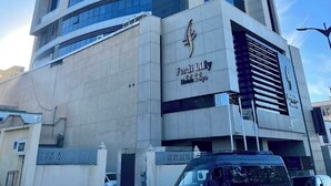 Un grand hôtel moderne à la façade incurvée, avec un logo bien visible sur la partie inférieure.