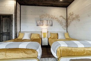 Ein Schlafzimmer mit zwei Betten, Holzwänden, einem Nachttisch mit Lampe und einer Wanddekoration.