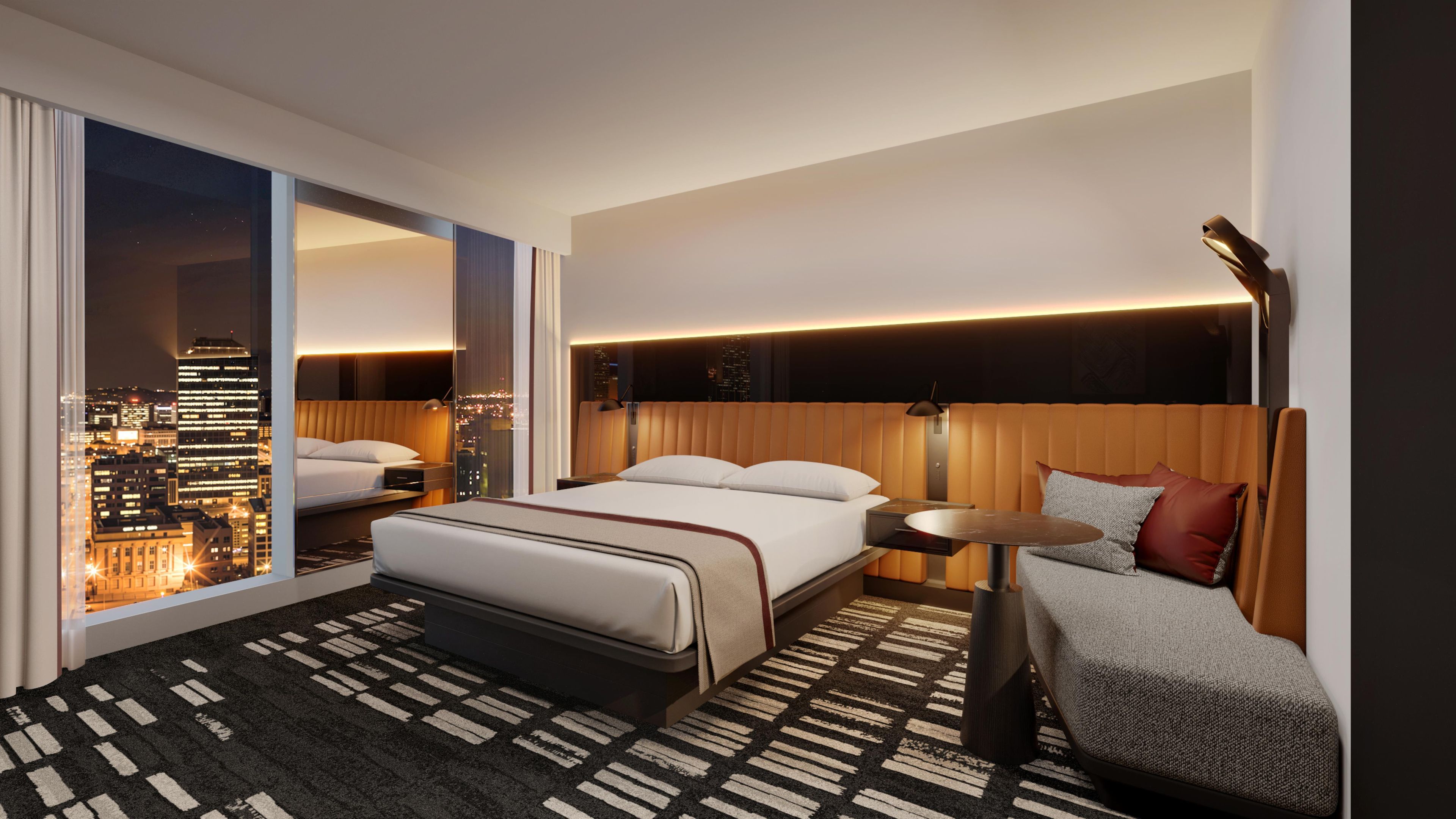 A modern hotel room with a large bed, a seating area, a city view, and a cityscape visible through the window.