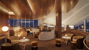 A modern lounge area with a curved wooden ceiling, seating arrangements, and a city view.