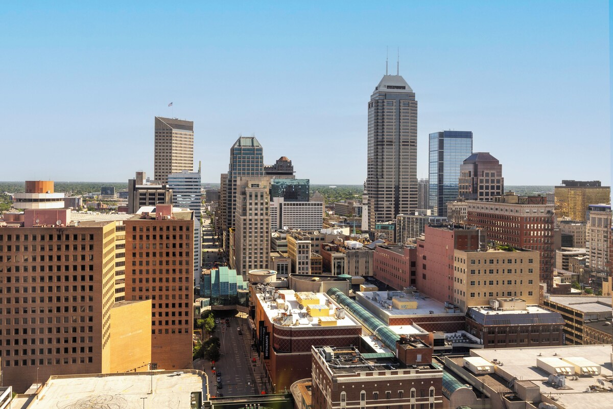 A cityscape with various buildings, including a prominent skyscraper with a unique design.