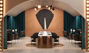 A modern dining area with a long table, chairs, and a unique wall design.