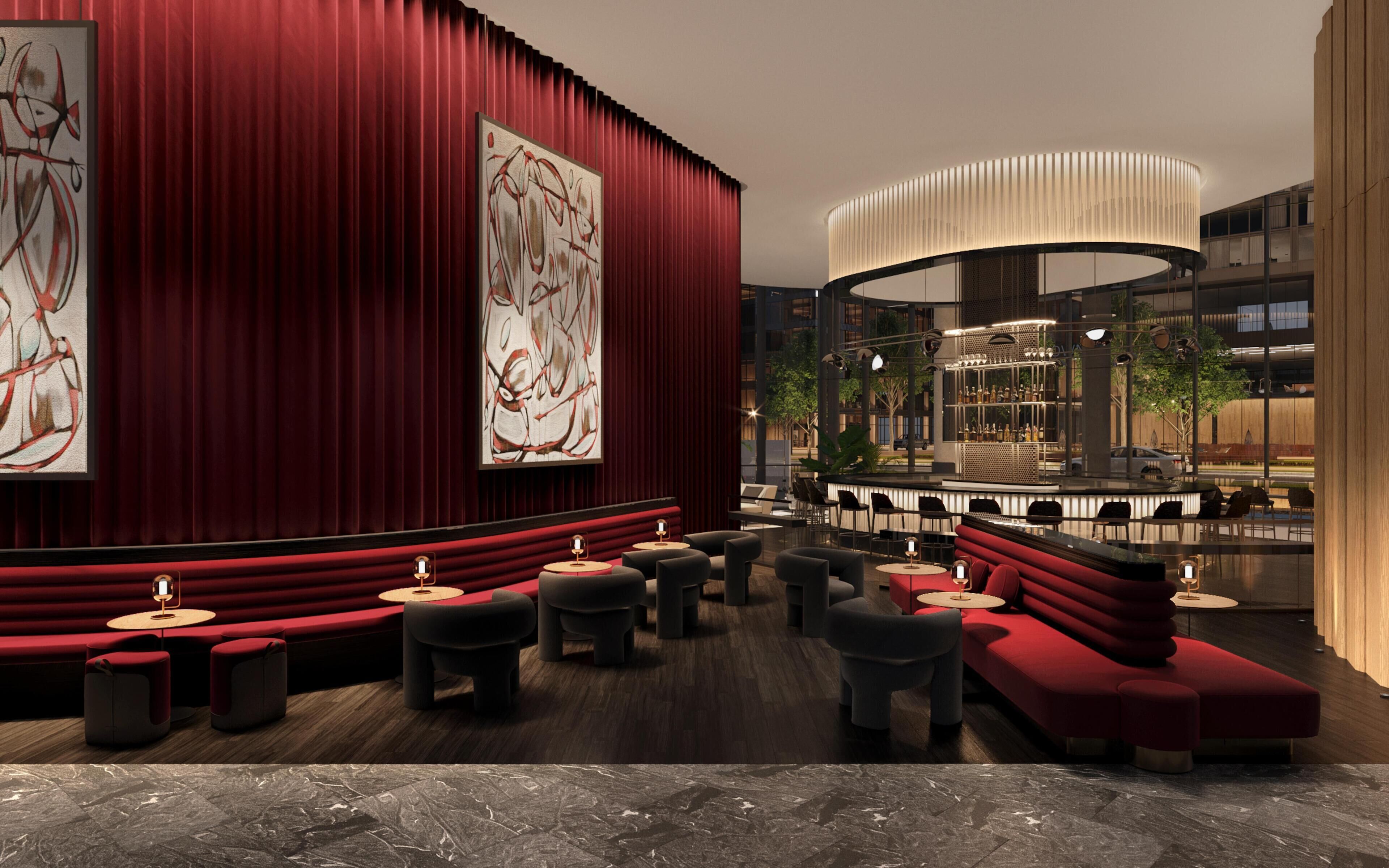 A modern lounge area with red seating, abstract art, and a bar with a unique light fixture.