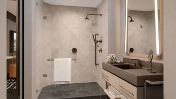 Een moderne badkamer met een grote spiegel, twee wasbakken, een douche en marmeren vloeren.
