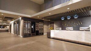A modern hotel lobby with a reception desk, seating area, and wine display.