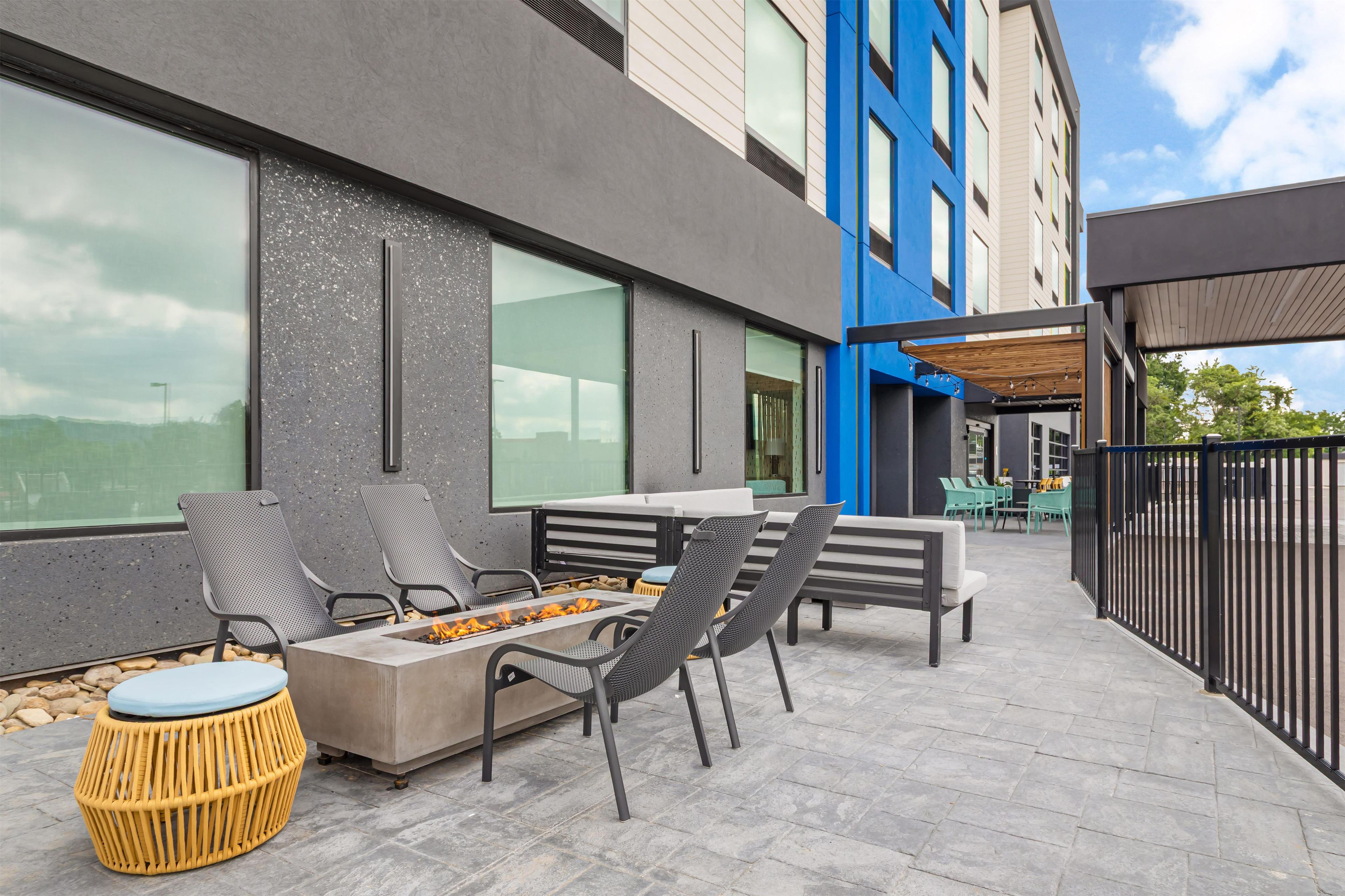 An outdoor seating area with a fire feature, chairs, and a table.