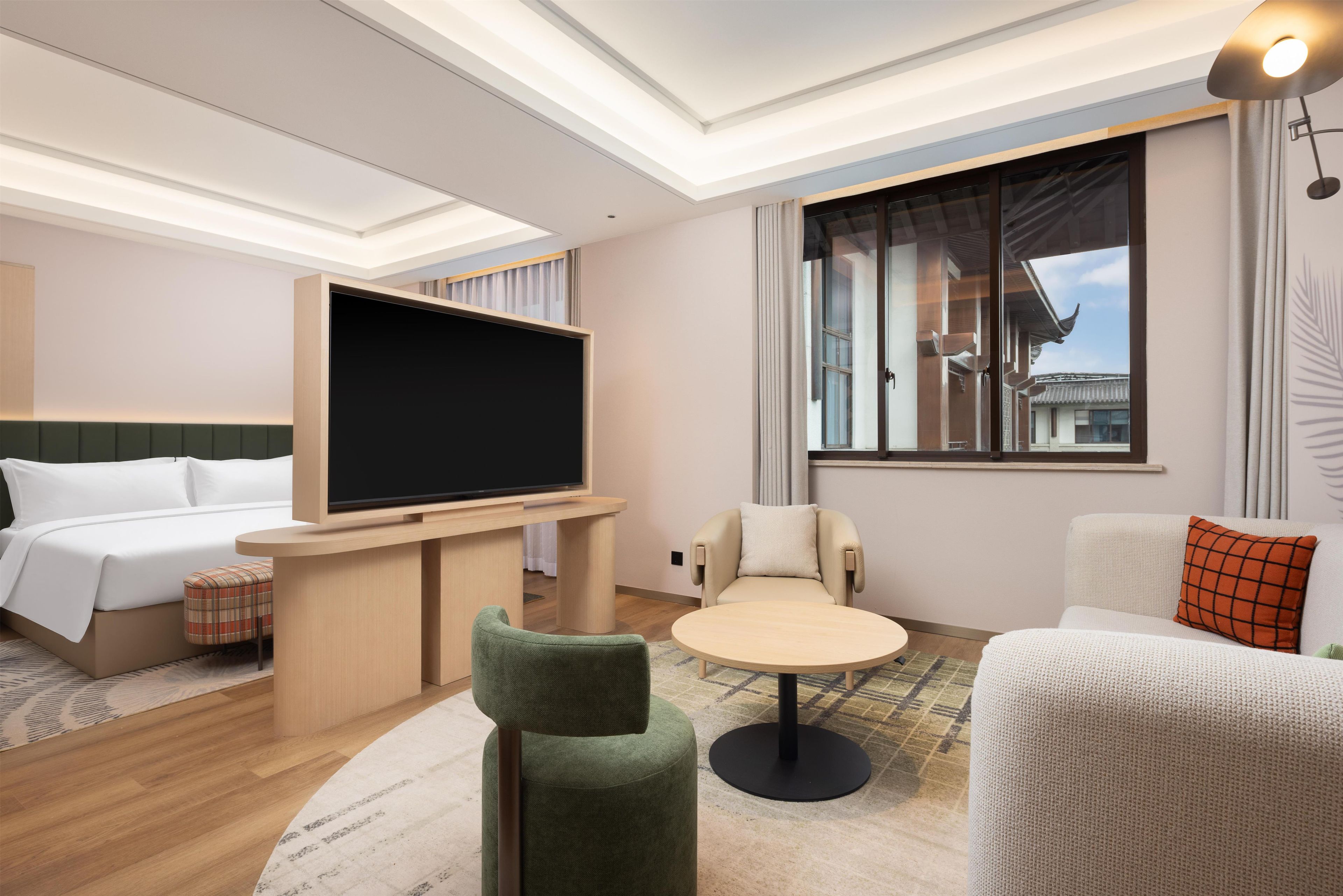 Ein Hotelzimmer mit einem Bett, einem Fernseher, einem runden Tisch und einem Sofa.