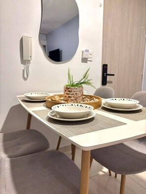 A dining table with four plates, a central decorative bowl, and a potted plant. - Casa Arena Confort Torices (Cartagena)