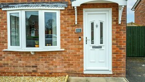 A brick house with a white front door, a bay window, and a small garden area. - 2 Bed home, close to the hospital and town centre - Pass the Keys (Shrewsbury)