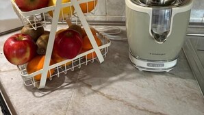 Eine Küche mit Obstkorb auf der Arbeitsfläche und einem Entsafter.