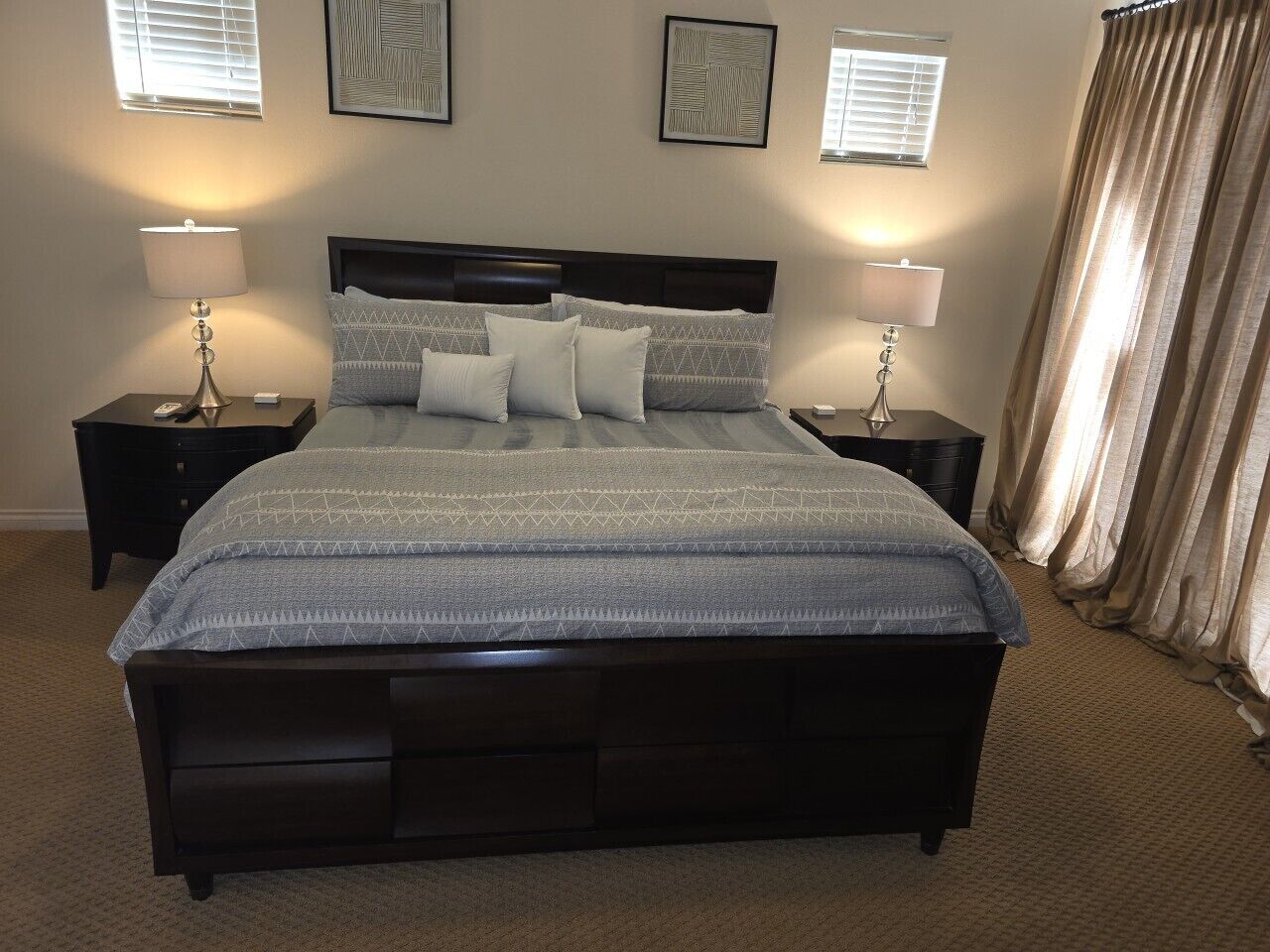 A bedroom with a large bed, two bedside tables, and a headboard.
