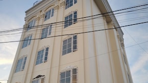 A multi-story building with a classic architectural style, featuring a balcony on the second floor and a ground-level entrance.