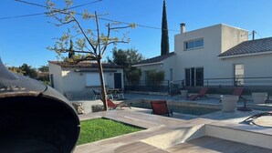 Ein modernes Haus mit Swimmingpool, Außenbereich und gepflegtem Rasen.