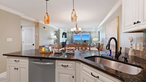 Cozinha moderna com ilha central, eletrodomésticos de aço inoxidável e iluminação pendente.