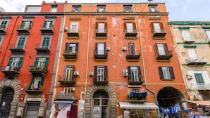 A multi-story building with balconies, a storefront, and a street in front. - BORGO VERGINI SUITES (Naples)