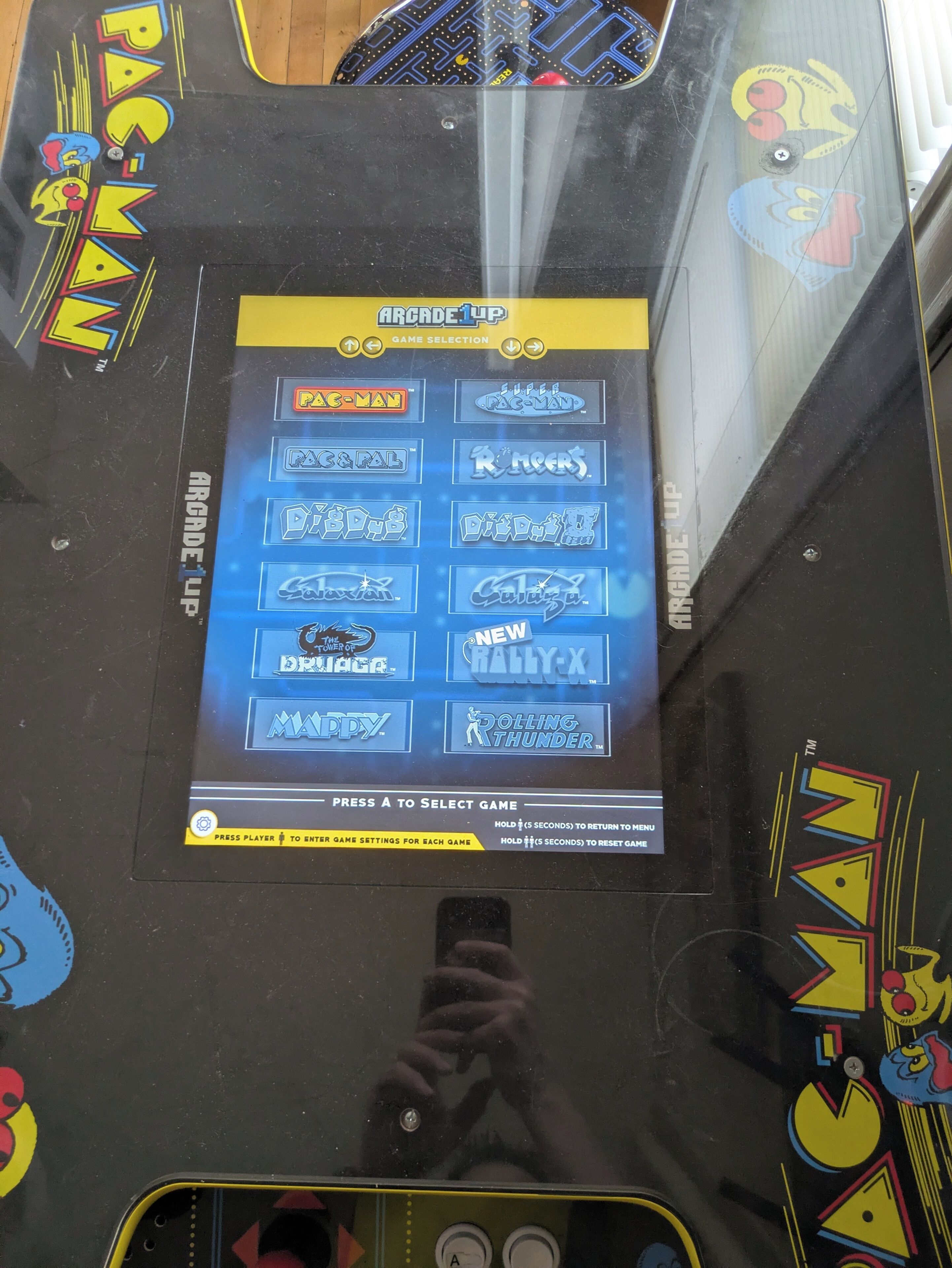 Een scherm met een overzicht van verschillende spelletjes in de speelhal.
