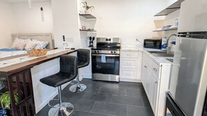 Une cuisine compacte comprenant un coin repas, un four encastré, un four à micro-ondes et un réfrigérateur.