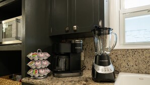 Eine Küche mit Kaffeemaschine, Mixer und Joghurtbehältern.