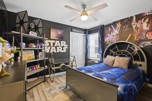 Ein Schlafzimmer im Stil von Star Wars mit einem Bett, einem Regal und einem Deckenventilator.