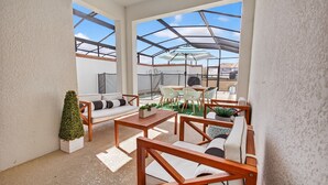 Un patio techado al aire libre con asientos, una mesa y una pequeña planta en maceta.