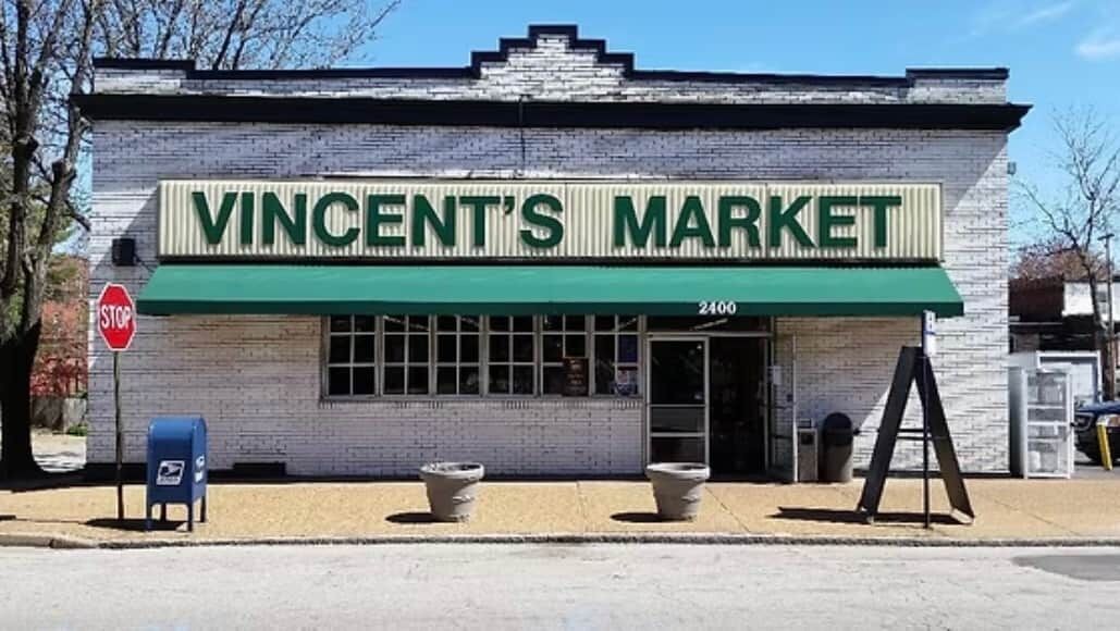 A storefront with a green awning and the sign 'VINCENT'S MARKET' above the entrance.