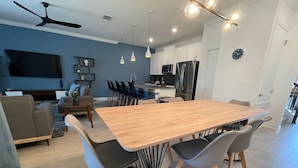 A modern kitchen with a dining area, a flat-screen TV, and a ceiling fan. - Last Minute Disney Getaway! Private Pool & Themed Bedrooms. Book Now! #165355 (Orlando)