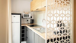 A compact kitchen with a microwave, refrigerator, and sink. - The Grande Large mobile home is a fully equipped, comfortable accommodation for 6 people, ideal in any season thanks to its three bedrooms, terrace, air conditioning, and central heating. (Dochamps)