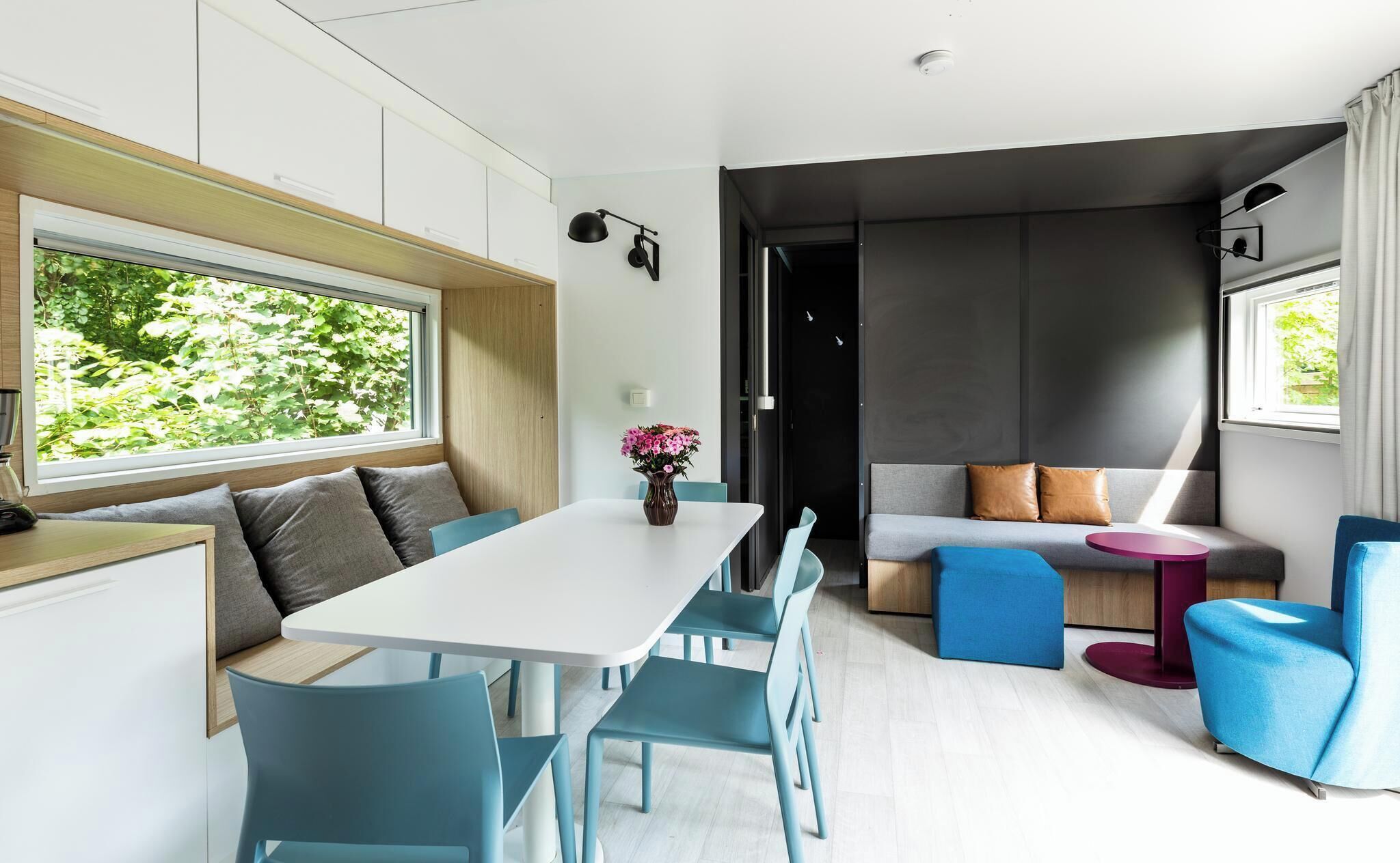 A modern interior with a dining area, a sofa, and a small table.