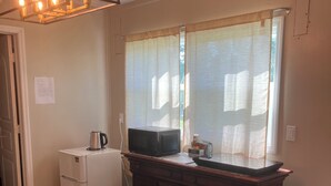 A kitchen with a refrigerator, microwave, and a cabinet. - Comfortable 1-bedroom apartment close to Beach with AC- Vero Beach (Vero Beach)