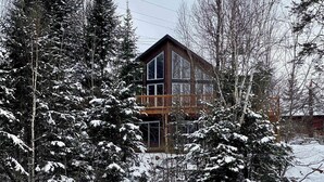 Eine Hütte, umgeben von schneebedeckten Bäumen.