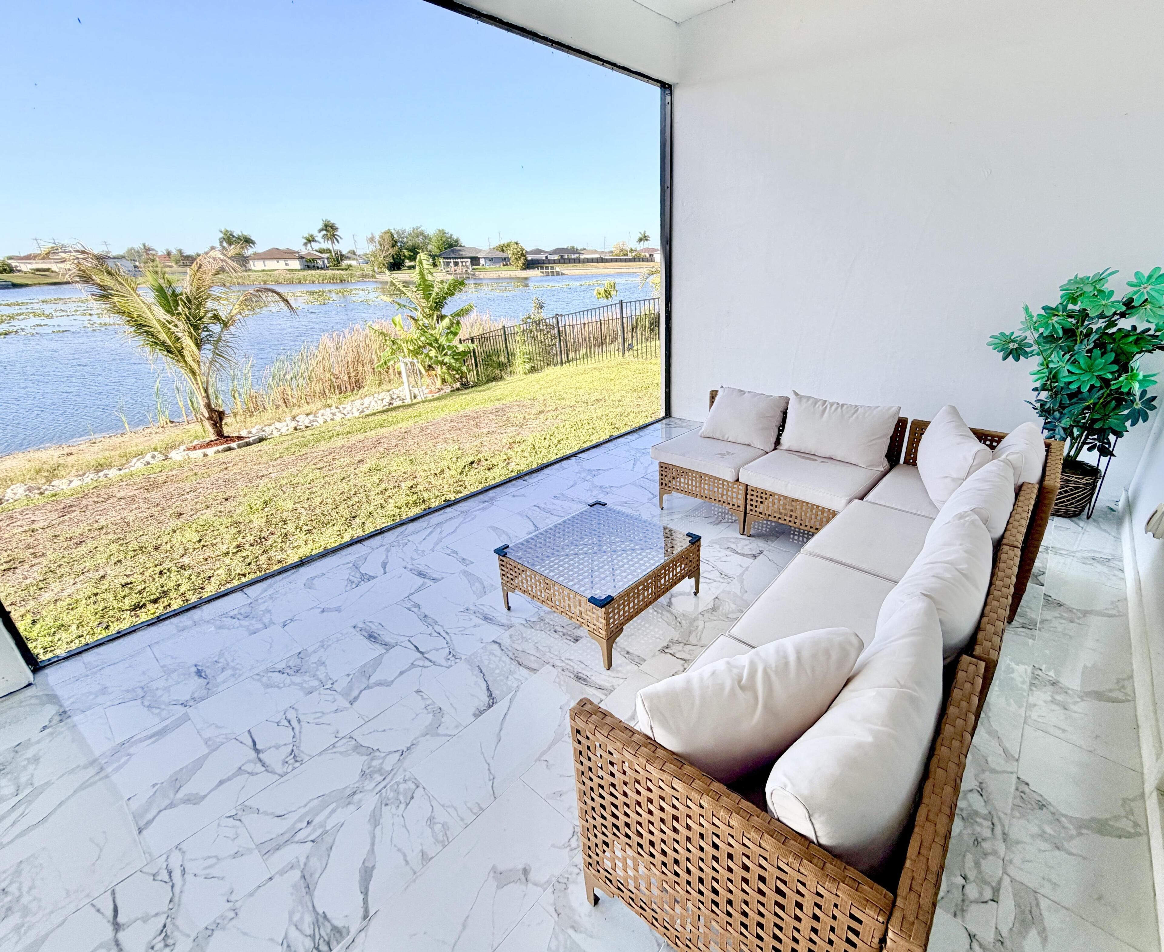 Ein modernes Wohnzimmer mit einem großen Panoramafenster, einer Couch, einem Couchtisch und einem Blumentopf.