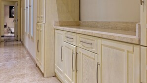 A kitchen with light-colored cabinets and a marble floor. - VESTA  - Luxury APT - 4BR - New Cairo (II) (New Cairo City)