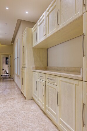 A kitchen with light-colored cabinets and a marble floor. - VESTA  - Luxury APT - 4BR - New Cairo (II) (New Cairo City)