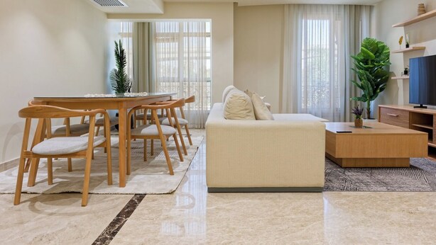 A modern living room with a sofa, dining table, chairs, a TV, and a large window with curtains. - VESTA  - Luxury APT - 4BR - New Cairo (II) (New Cairo City)