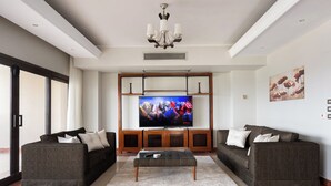 A modern living room with a flat-screen TV, two sofas, a coffee table, and a chandelier. - VESTA  - Luxury APT - 4BR - Agouza (I) (Giza)
