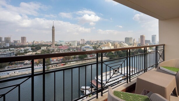 A balcony with a view of a cityscape, including a river and a tall tower. - VESTA  - Luxury APT - 4BR - Agouza (I) (Giza)