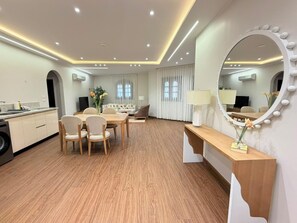 A hotel room with a dining area, a vanity with a mirror, and a wooden floor. - VESTA  - Luxury APT - 3BR - South Teseen (III) (New Cairo City)