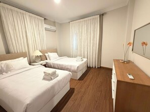 A hotel room with two beds, a wooden dresser, a desk, and a mirror. - VESTA  - Luxury APT - 3BR - South Teseen (III) (New Cairo City)