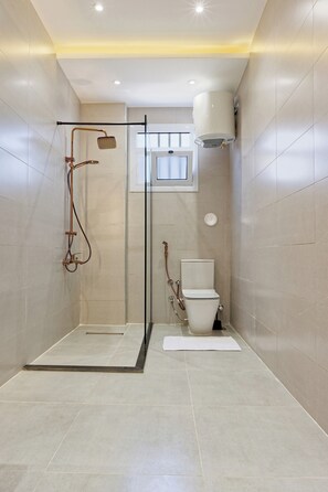 Un bany modern amb plat de dutxa, vàter i bidet.