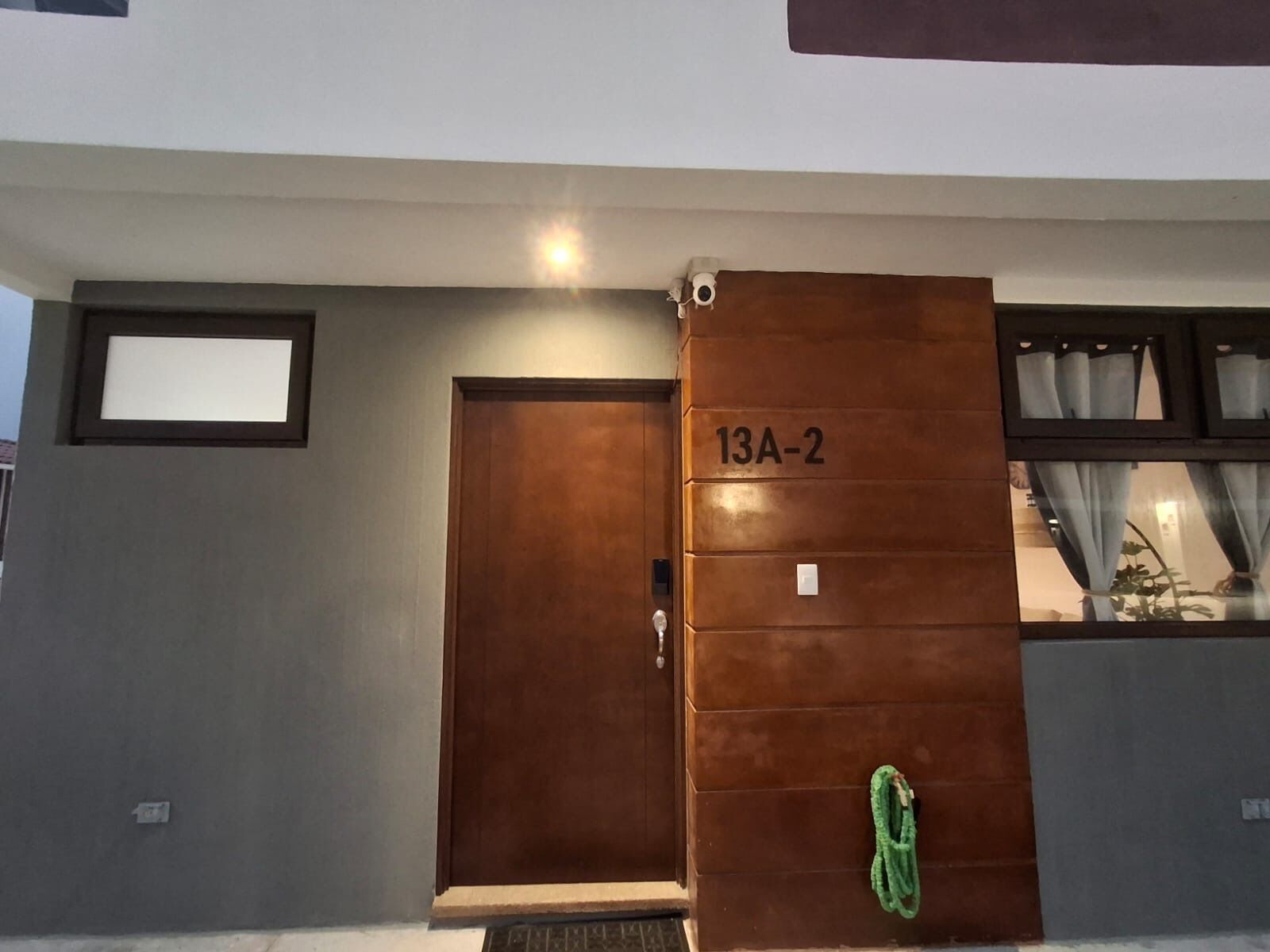 A modern building with a large wooden door labeled '13A-2'.