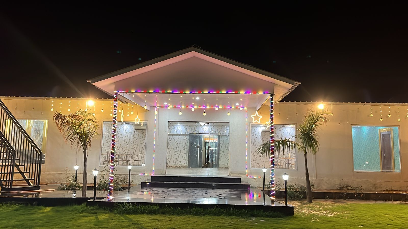 A building with a covered entrance, outdoor lighting, and a staircase.
