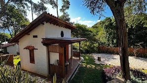 Un edificio pequeño de un solo piso con techo inclinado, un porche y una ventana pequeña.