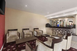 A hotel lobby with seating, a bar area, and a counter with various items. - Oldbury Birmingham (Oldbury)