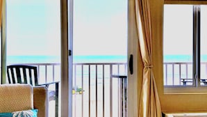A room with a view of the ocean, a chair, and a table. - Luxury Oceanfront 2BR 2BA Condo Private Balcony Beach Pool Full Kitchen Gym (Virginia Beach)