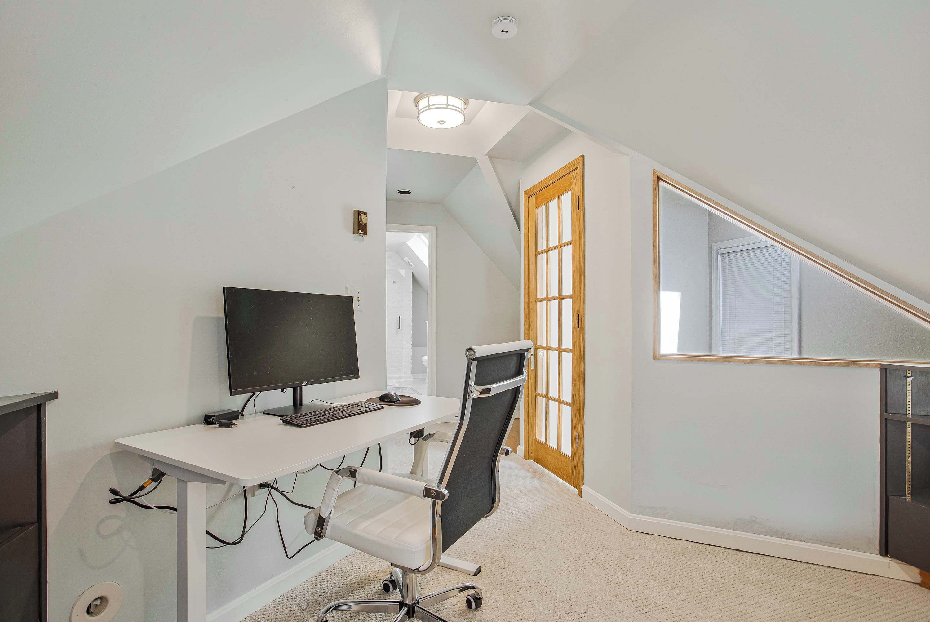 A modern office space with a desk, computer, and ergonomic chair.