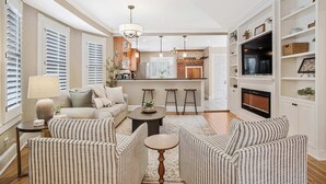 A living room with striped sofas, a coffee table, and a TV. - Annapolis Gem- Tranquil 4 BR Murray Hill Victorian (Annapolis)