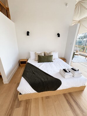 A spacious bedroom with a large bed, wooden flooring, and a view of the outdoors. - The Flats - Premium Dome at Granda Rose Retreat (Branch)
