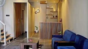 Een modern interieur met een blauwe bank, een glazen tafel en een houten scheidingswand.