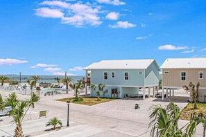 A coastal building complex with a pool, palm trees, and a clear sky. - 107 Seven Palms, Under The Sea (Fulton)